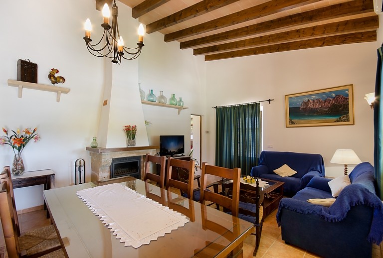Wohnzimmer Essbereich Tisch Stuehle Sofas Kamin Fernsehgeraet