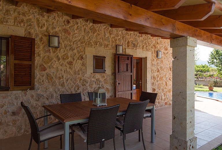 Terrasse Esstisch Stuehle Fenster Natursteinwand Pool