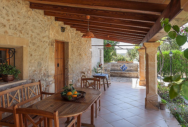 Terrasse Überdachung Gartentisch Stühle Büsche