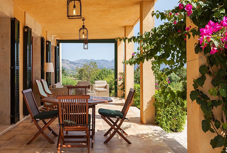 Gartenbereich Terrasse Teakholztisch Stuehle Rattanmoebel Pflanzen