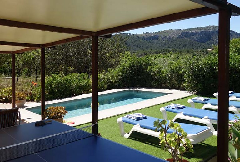Pool Tisch Stuehle Sonnenliegen Rasen Berge