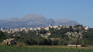 Das Dorf Buger auf einem Hügel und das Gebirge dahinter