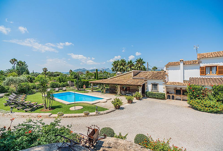 Pool mit Sonnenliegen und Rasenfläche vor der Finca