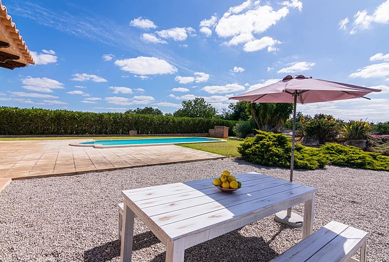 Gartentisch mit Sonnenschirm am Pool