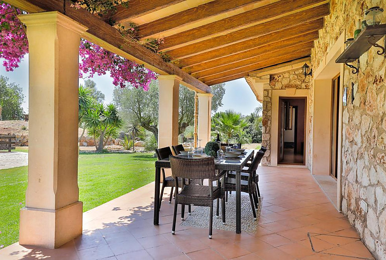 Terrasse mit Vordach und Esstisch und Blick in den Garten