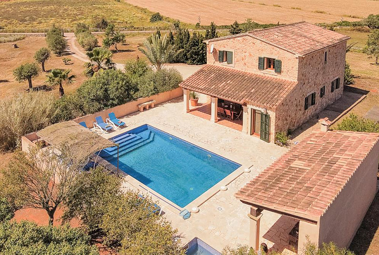 Grundstück mit Pool und Sonnenliegen vor dem Ferienhaus