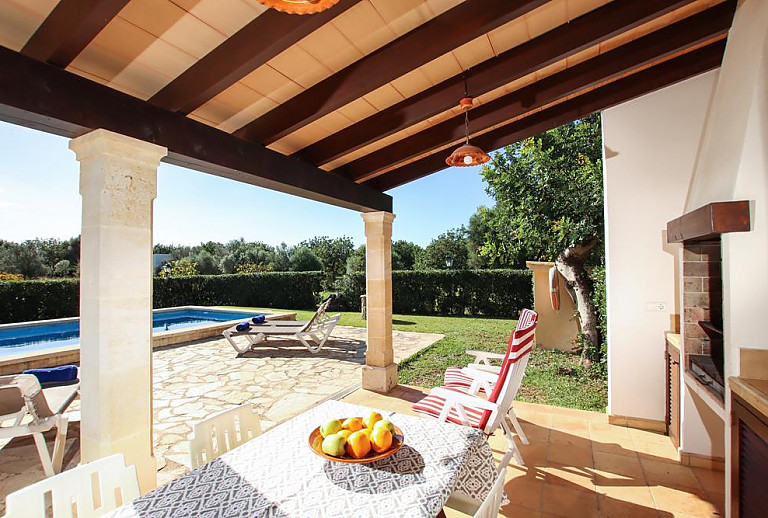 Terrasse mit Esstisch und Poolblick