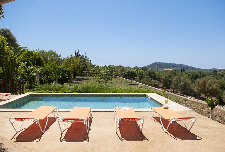 Poolbereich mit Sonnenliegen und Weitblick